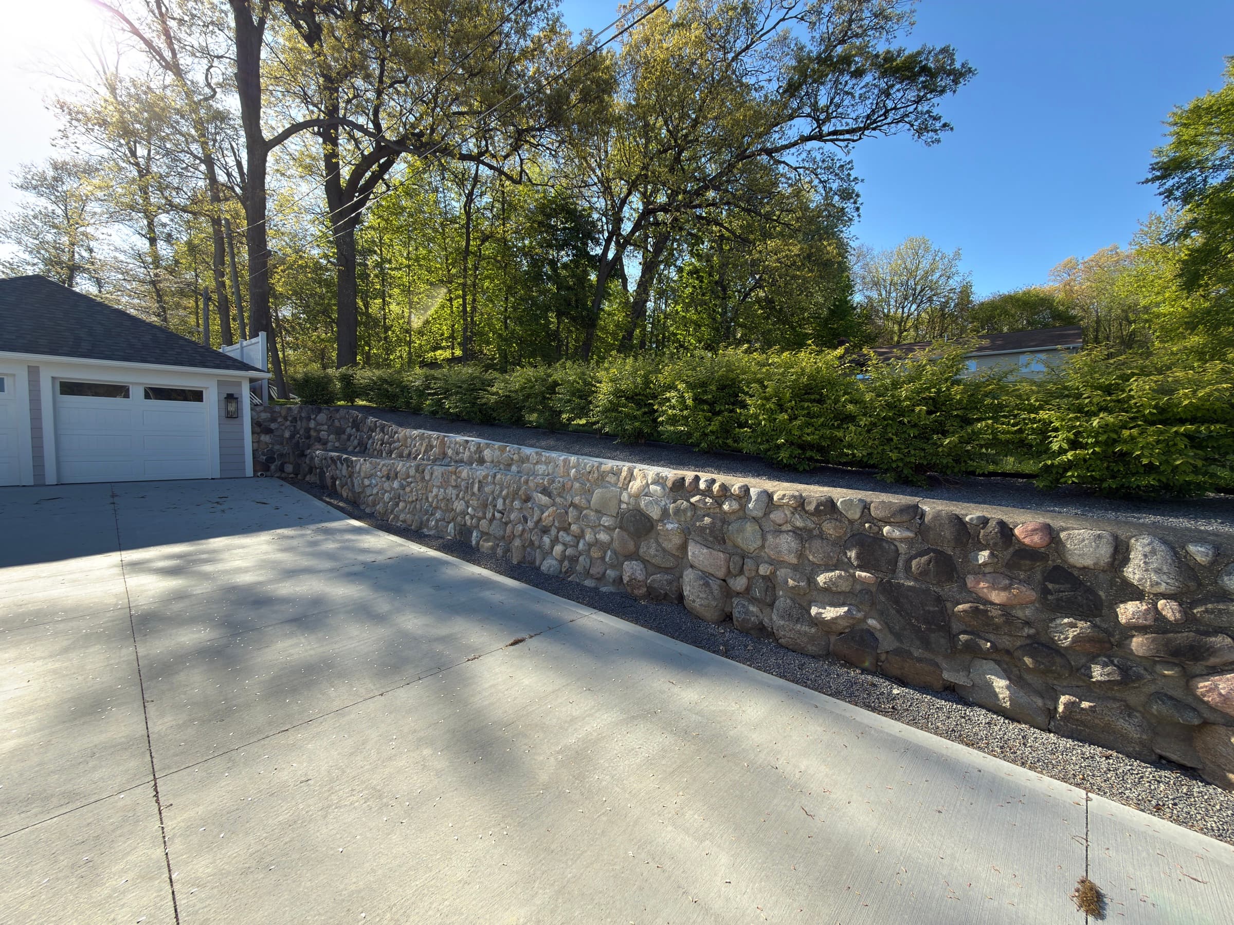Long fieldstone retaining wall alongside a concrete driveway, Southwest Michigan